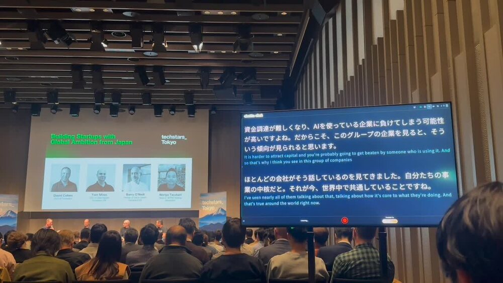 A Techstars Tokyo session with the translated feed beside the slides